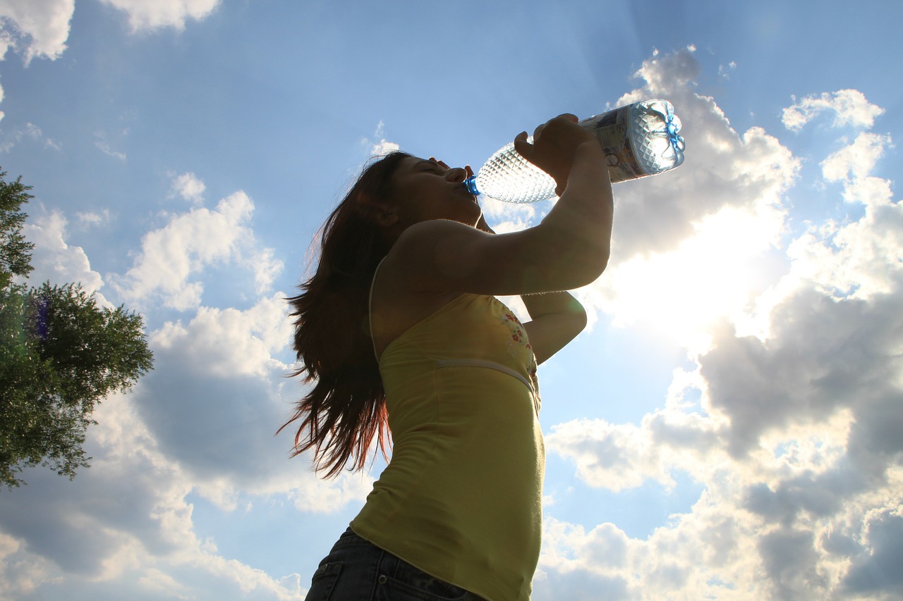 אישה שותה מים למניעת דלקת בשתן